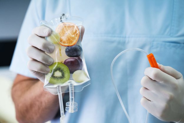 Doctor Holding Saline Bag With Fruit Slices Inside In Hospital